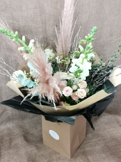 Pretty Pampas Grass - A beautiful seasonal Aqua arrangement created with gorgeous pampas grass (natural or pink dependent on availability). Presented in a Kraft gift bag and finished with a luggage tag.